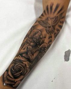 a person with a tattoo on their arm holding a rose and a bird in the sky