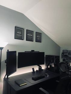 a desk with a computer monitor, keyboard and speakers on top of it in a room