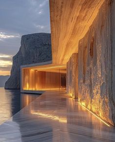 the interior of a building with water and cliffs in the background