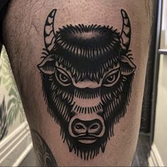 a bull tattoo on the leg of a man's calf, which is black and white