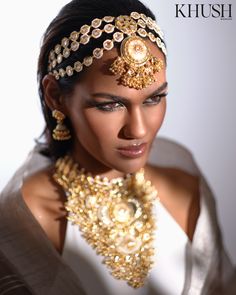 a woman wearing a gold necklace and head piece