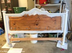 a bed frame is being made with white paint and wood planks on the sides