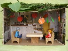 a doll house with furniture and decorations on the outside, including two people sitting at a table