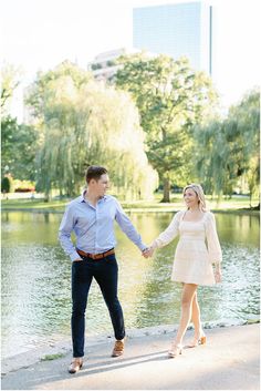 an engaged couple holding hands by the water