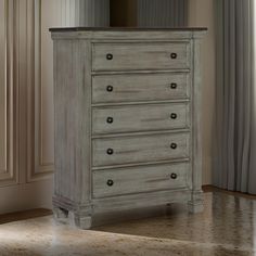 a white dresser sitting next to a window in a room