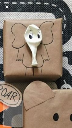 an elephant shaped object sitting on top of a piece of brown paper next to a bag