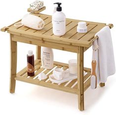 a wooden table topped with lots of personal care items next to a towel and soap dispenser