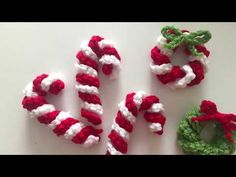 crocheted candy canes and christmas wreaths made from yarn on a table