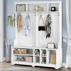 a white coat rack filled with coats and purses next to a blue painted wall