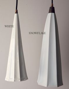 two white hanging lights with black cords attached to them and the words snowflake below