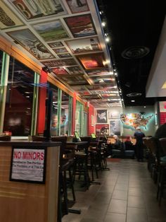 the inside of a restaurant with no mirrors on the ceiling and people sitting at tables