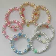 four bracelets with pearls and stars on them