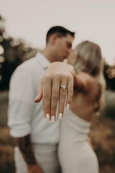 a man and woman are holding their hands close to each other as they pose for the camera