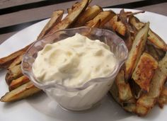 a white plate topped with french fries and dip