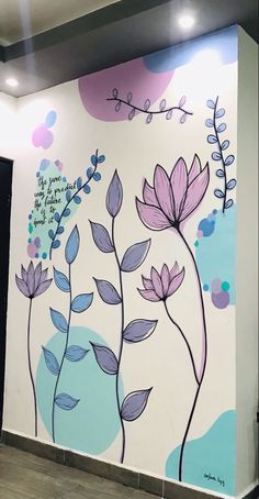 a wall with flowers painted on it in a room that is decorated with blue and purple paint