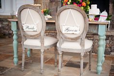 two chairs with signs on them sitting in front of a table and chair set up