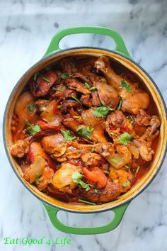 a green pot filled with meat and vegetables