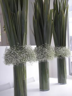 three tall vases with baby's breath flowers in them