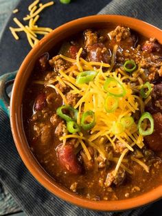 a bowl filled with chili and cheese on top of a table