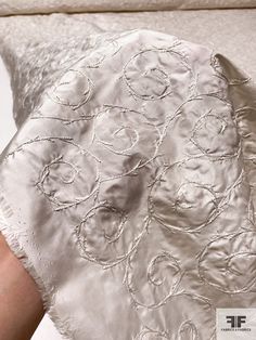 the back of a woman's white dress with silver circles on it