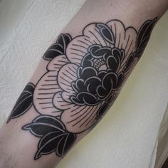 a black and white flower tattoo on the arm