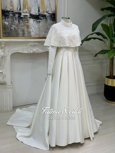 a white wedding dress on display in front of a painting and fireplace mantelpiece