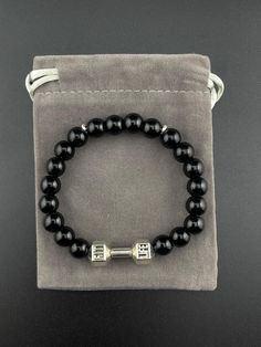 -Application: weighted bracelet length of 20CM elastic band with 8MM high-quality round Onyx stones, designed to relieve pressure, meditation, yoga, and essential oil diffusion. -This striking accessory features high-quality Black Onyx beads, exuding a rich, deep black hue that evokes a sense of power, sophistication, and confidence. -As a powerful grounding stone, it promotes emotional stability, mental clarity, and focus, while protecting negative energies and psychic attacks. -Black Onyx is a Classic Black Beaded Bracelets As Gift, Classic Black Bracelets With 8mm Beads, Adjustable Black Beaded Bracelets With Polished Beads, Classic Black Onyx Bracelet, Classic Black Onyx Bracelets, Elegant Black Jewelry With 8mm Beads, Black Onyx 8mm Bead Jewelry, Black Onyx Jewelry With 8mm Beads, Black Onyx 8mm Beads Jewelry