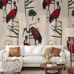 a living room with white couches and wallpaper decorated with red birds on it