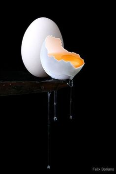 an egg is broken in half and sitting on a table with water dripping from it