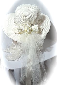 "This ivory summer bridal sun hat with a Victorian flair is covered in delicate lace appliques with pearl, rhinestone and sequin accents...just beautiful! Ivory Venice lace with crystal seed beads is the hat band. Ivory silk ribbon falls in long tails in back along with ivory crushed tulle that forms a soft bow with long tails. Ivory silk roses & vintage velvet leaves along with a rhinestone jewel & curled ostrich plumes fill the bouquet in back. Ivory satin braid finishes the edge of th Elegant White Hat For Vintage Events, Elegant White Hats For Vintage Events, Lace Wedding Hat, Bohemian Mini Hat With Short Brim For Wedding, White Brimmed Beach Fascinator, Vintage White Top Hat For Wedding, Bohemian Wide Brim Wedding Hat, Bohemian Short Brim Hats For Wedding, Velvet Leaves