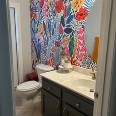 a bathroom with a colorful wallpapered shower curtain