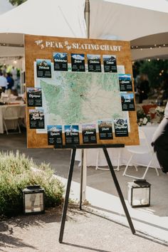 a map is on display in front of tables and umbrellas at an outdoor event