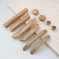 several wooden knobs are lined up on a white board with other wood knobs