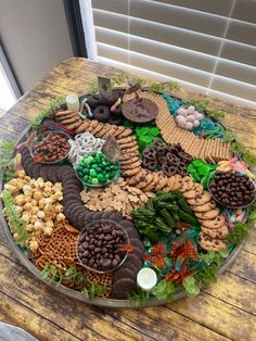 a platter filled with lots of food on top of a wooden table next to a window