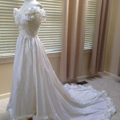 a white wedding dress on display in front of a window