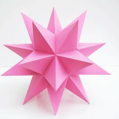 a pink origami star on a white background