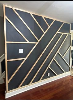 a room that has been painted black and white with wood trimmings on it