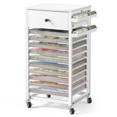 a white rolling cart filled with magazines and paper on top of each other in front of a white background