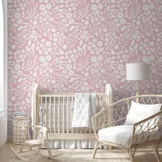 a baby's room with pink and white wallpaper