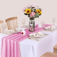 the table is set with pink and yellow flowers