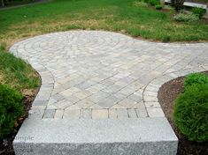 a brick walkway in the middle of a yard