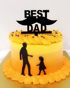 a yellow cake with black silhouettes of people holding hands and the words best dad on top