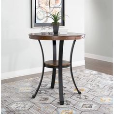 a table with a potted plant on top of it in front of a painting