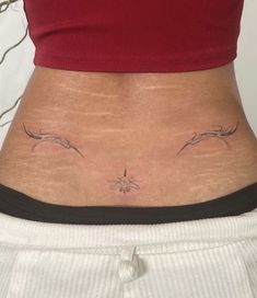 a woman's stomach with two small tattoos on her lower body and the upper part of her abdomen