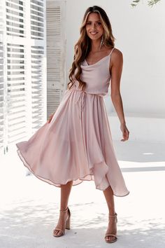 a woman in a pink dress posing for the camera