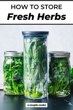 three jars filled with green vegetables sitting on top of a table