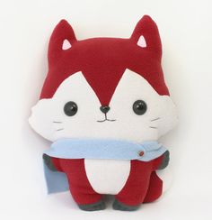 a red and white stuffed animal with a blue ribbon around it's neck on a white background