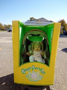 a doll in a green and yellow box