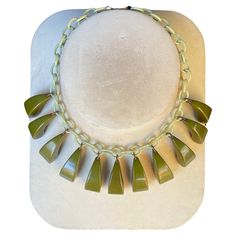 USA c.1930s. Unknown Maker, possibly Mazor. A light green Celluloid linked chain and (11) dark green Bakelite dangles. They have an organic feeling of arching reeds or arcing grass blades. American Industrial design mimicking and abstracting primitive forms. Length 16 3/4 by Width 1 1/2 in. Dangles L 5/8 x W 7/16 in. 70.6 gr Fair Condition because it has the older clasp, which retracts slowly and needs help often, but can stay closed. American Art Deco, 1930s Art Deco, Link Necklace, American Art, Industrial Design, Light Green, Dark Green, Jewelry Collection, Old Things