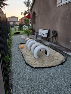 there is a sand sculpture in front of the house and some balls on the ground